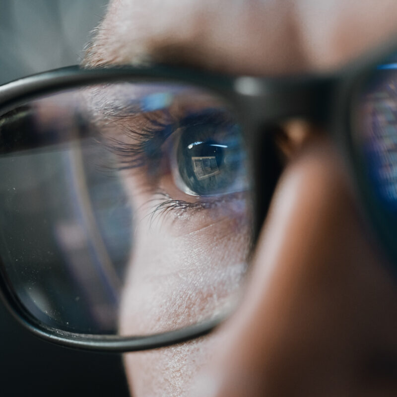 Close-up Portrait of Test Engineer Working on Computer, Line of Code Reflecting in Glasses